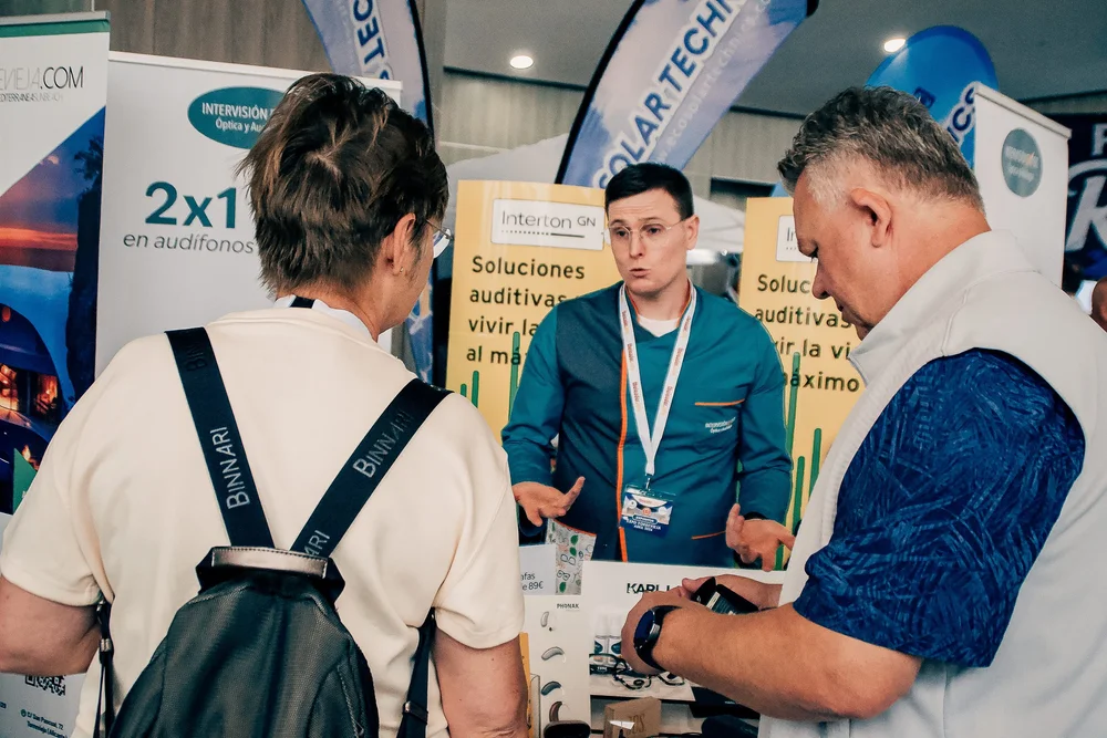 Audiology specialist explaining advanced hearing aid technologies to customers