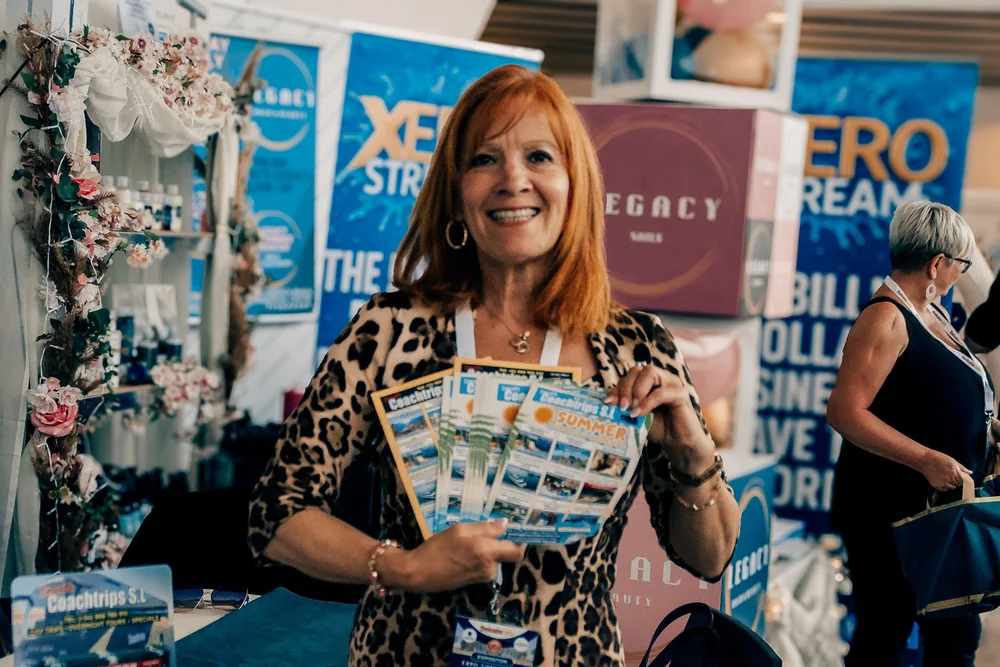 Exhibitor showcasing Costa Blanca excursion leaflets and beauty services