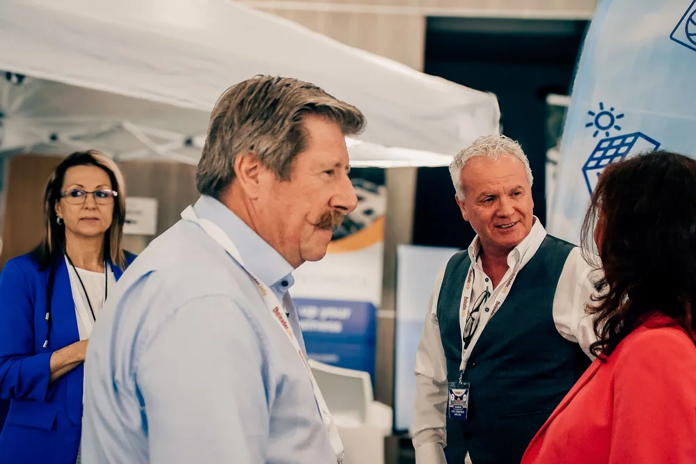 Stand holders in active discussion exploring business partnerships